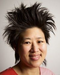 A woman with very messy hair is smiling for the camera.