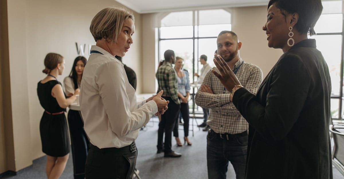 A group of people are standing in a room talking to each other.