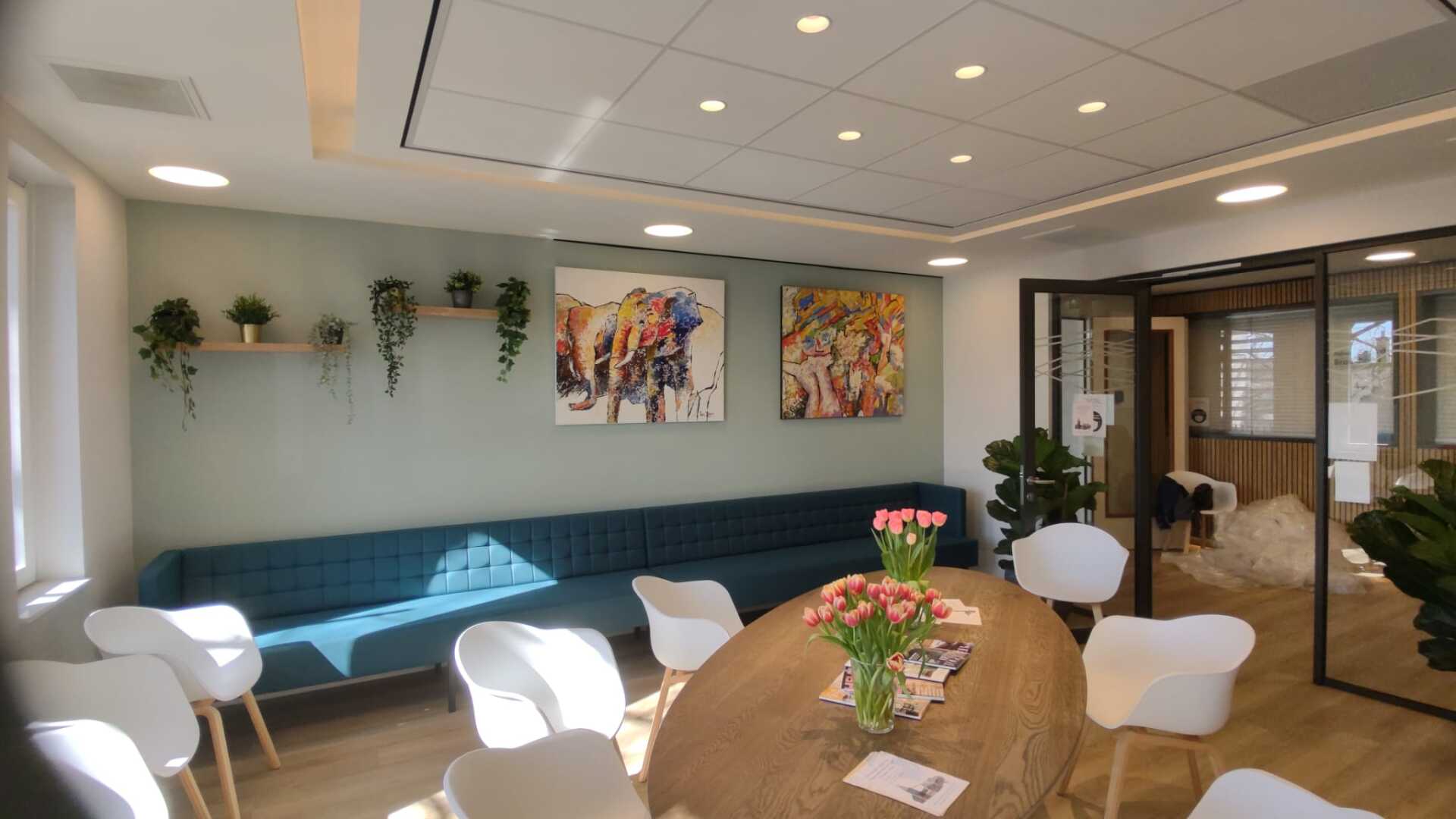 Een woonkamer met een tafel, stoelen en een bank.