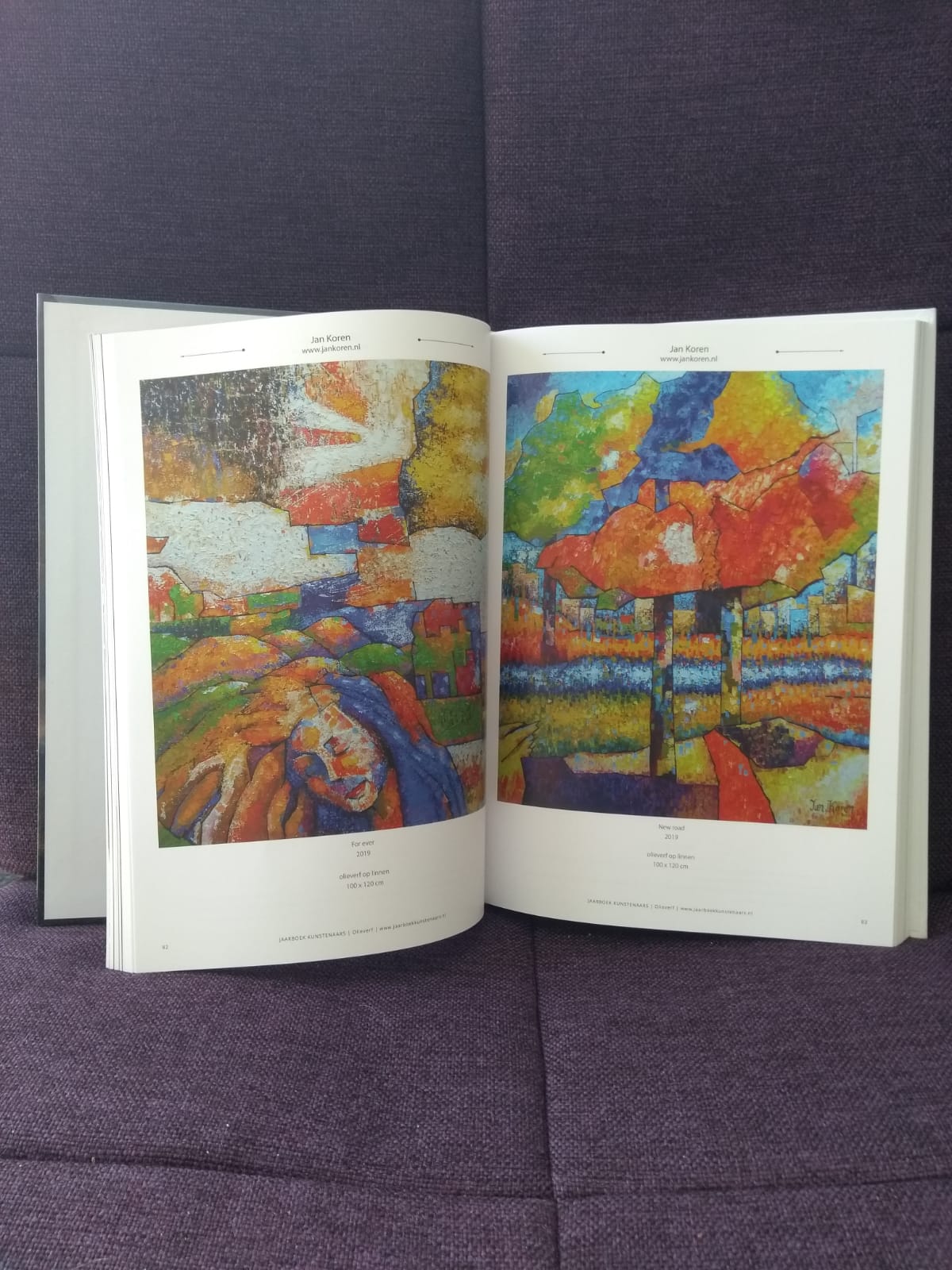 Een boek ligt open op een pagina met een schilderij erop