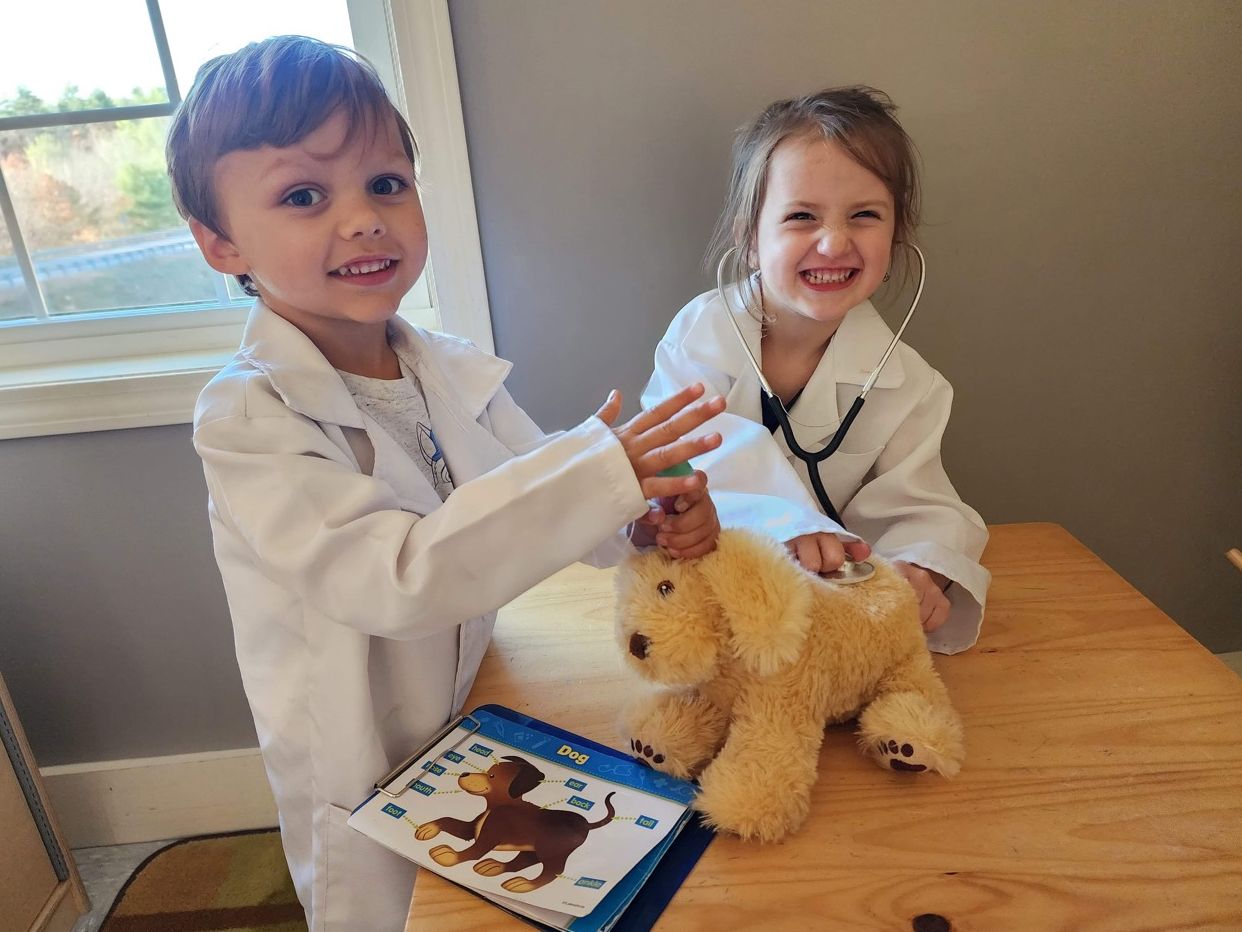 children playing doctor with stuffed toy