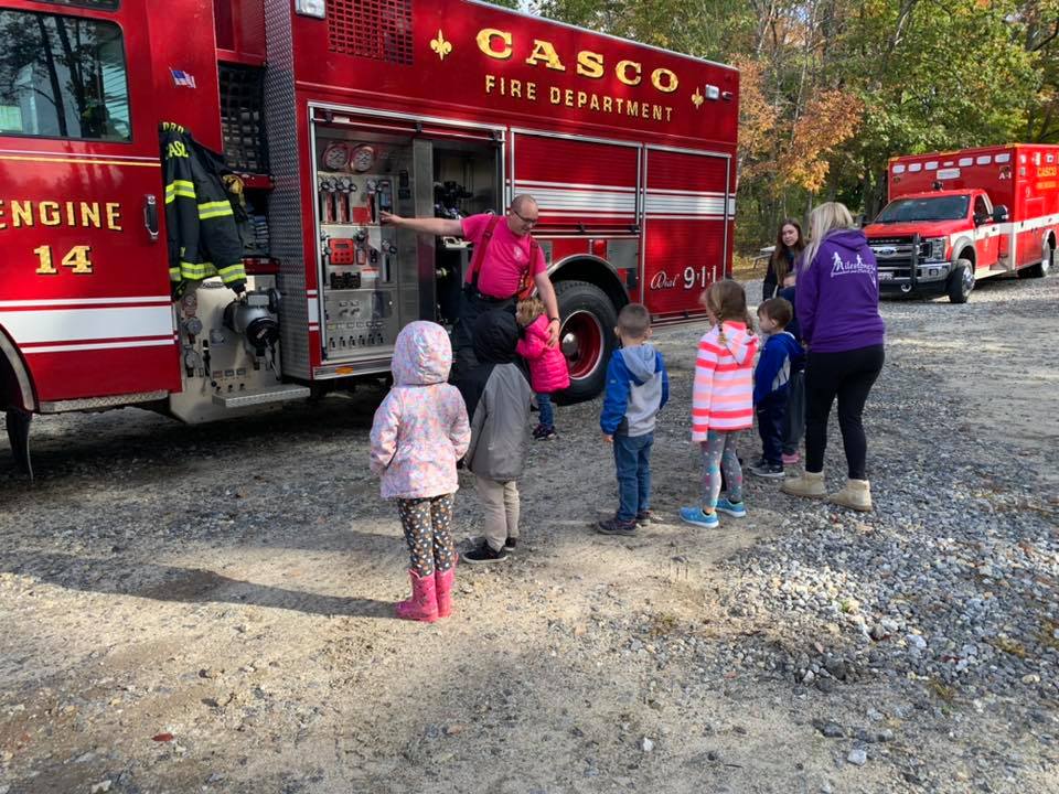 children watching fire truck with fire man