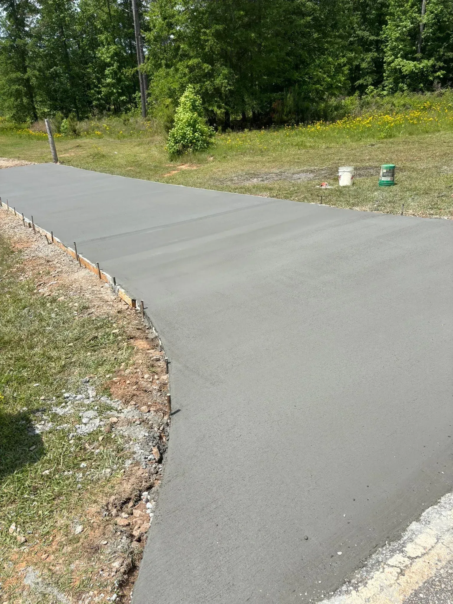 Newly poured concrete driveway with grassy edges.