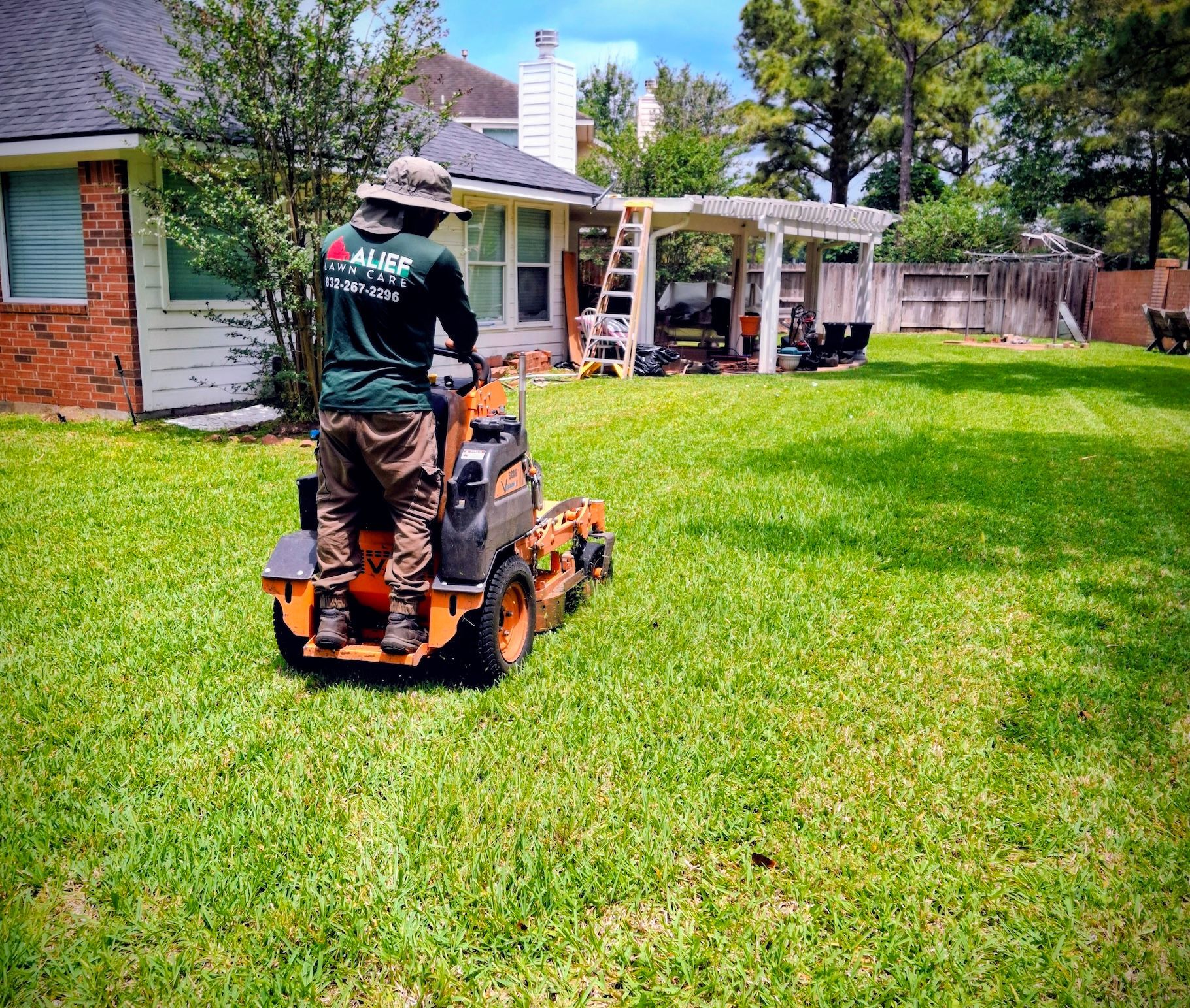 a man is riding a orange lawn mower on a lush green lawn