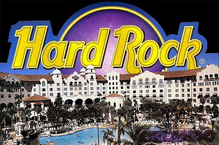 A hard rock sign with a hotel in the background