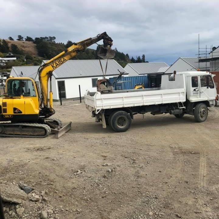 A yellow excavator is digging a hole in the dirt.
