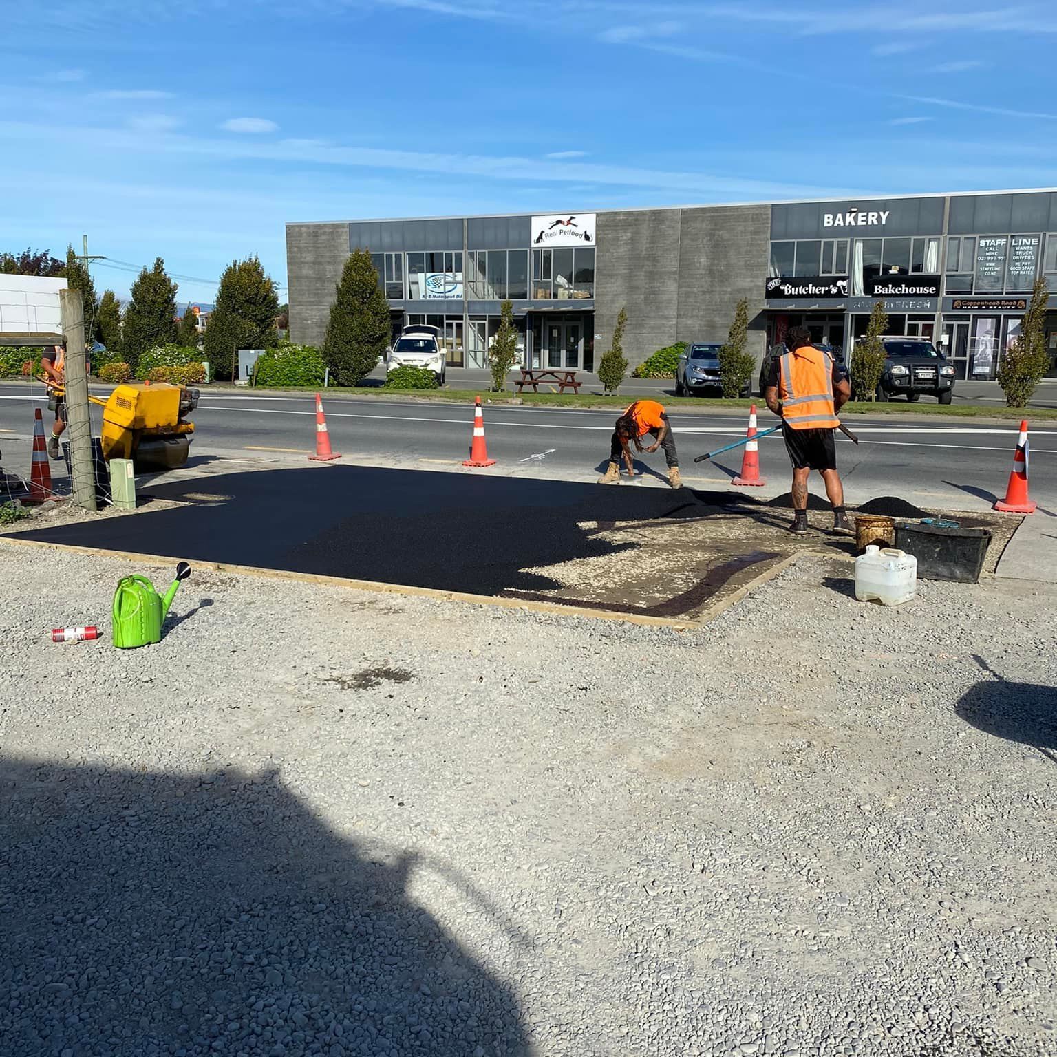 A truck is driving down a highway with a tractor on the back of it.