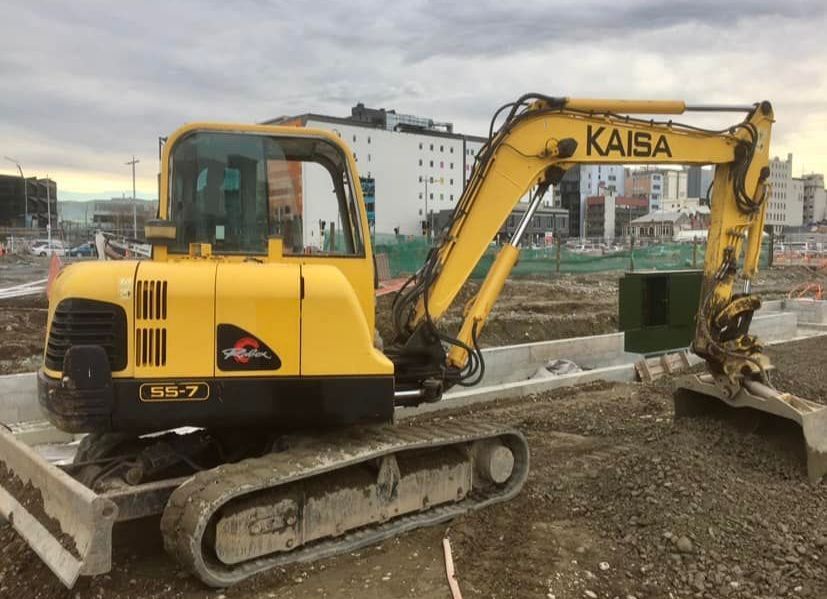 A large yellow excavator is demolishing a building A large yellow excavator is demolishing a building