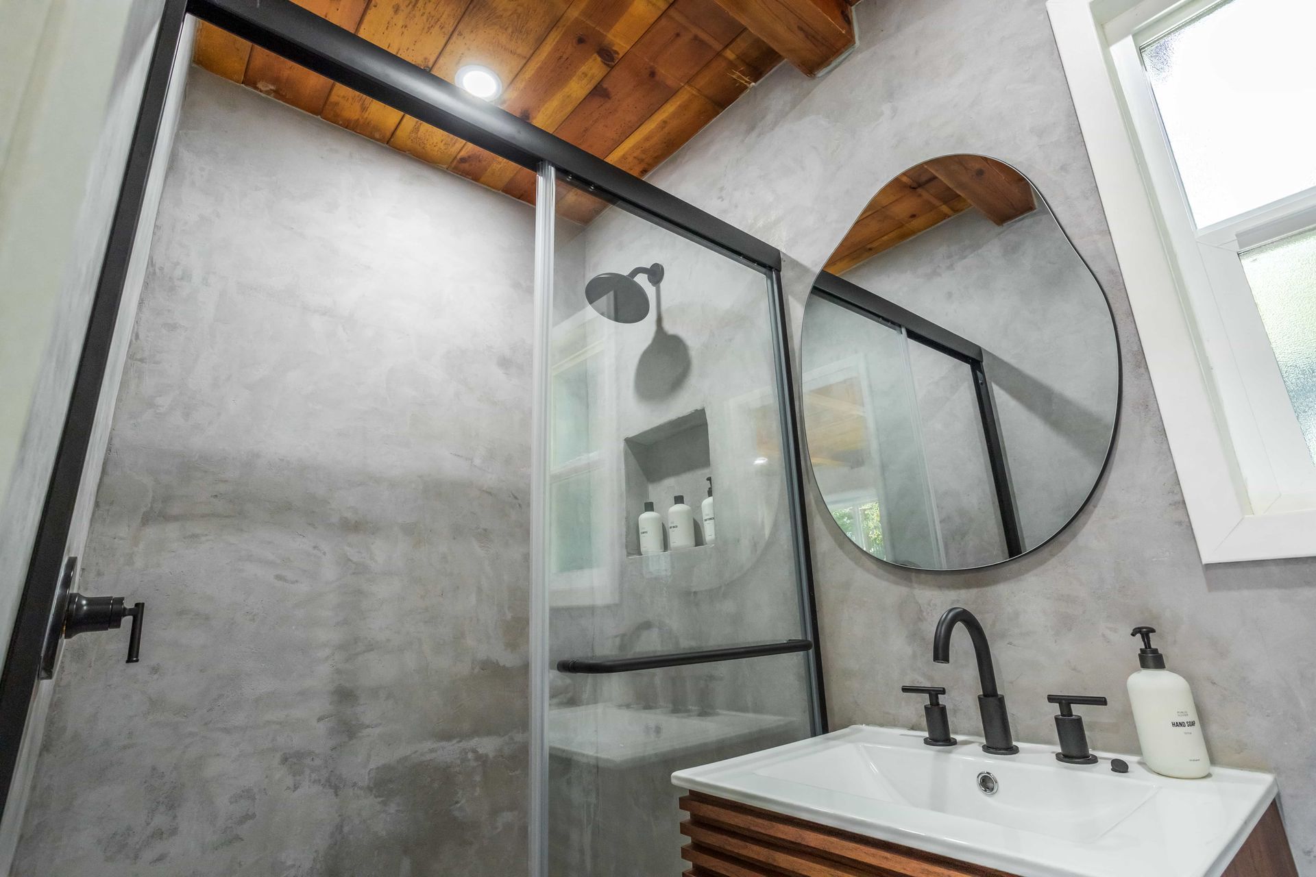 A bathroom with a sink , shower , and mirror.