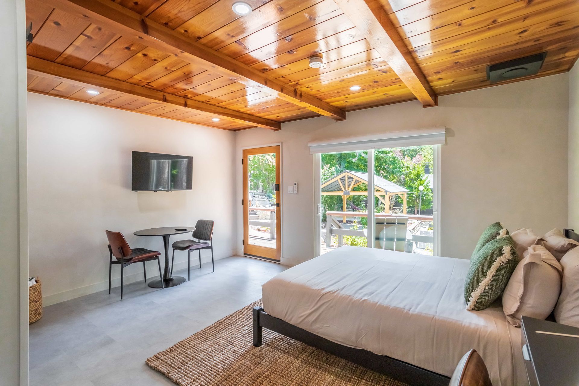 A bedroom with a king size bed , table and chairs.