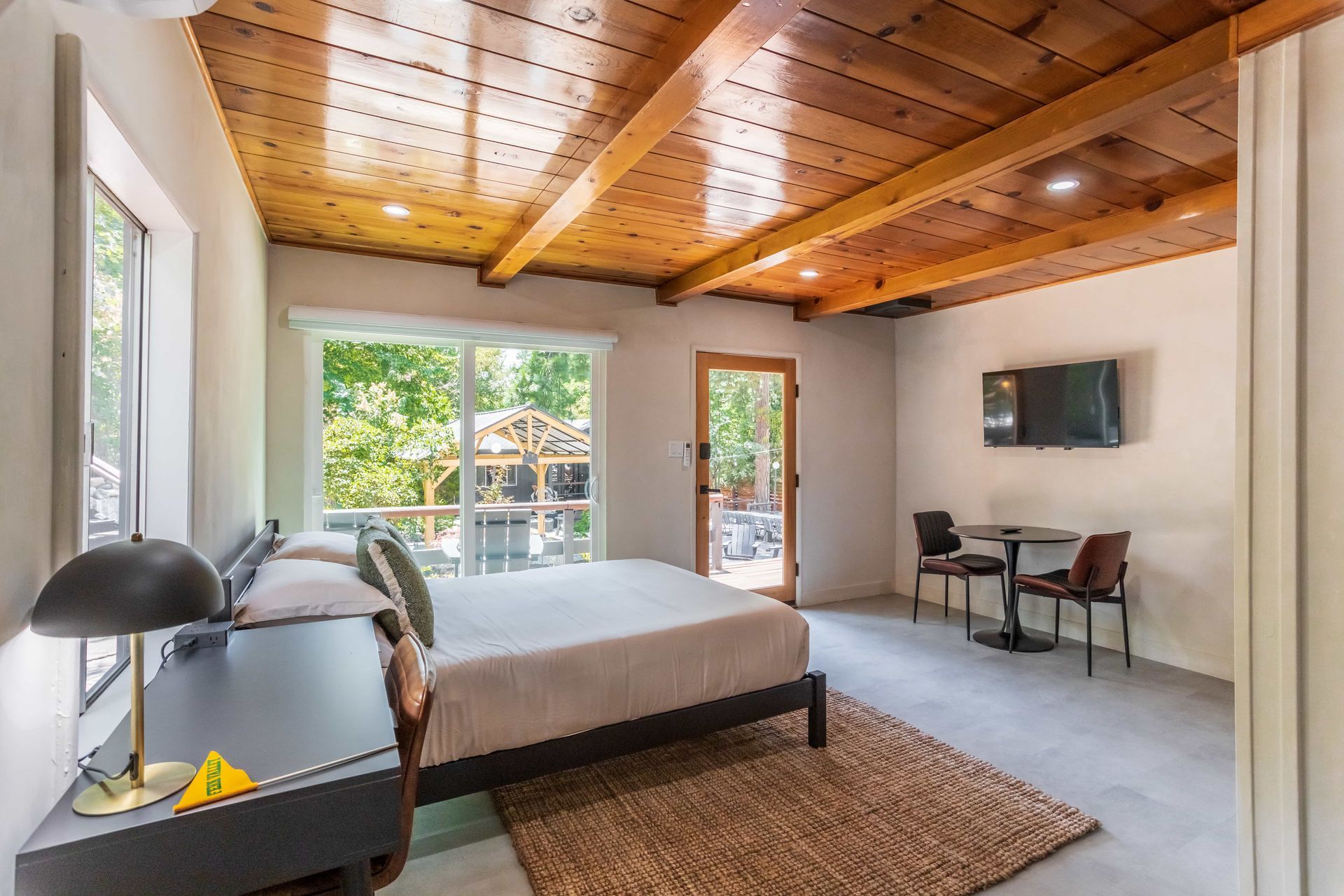 A bedroom with a king size bed , a table , chairs and a television.