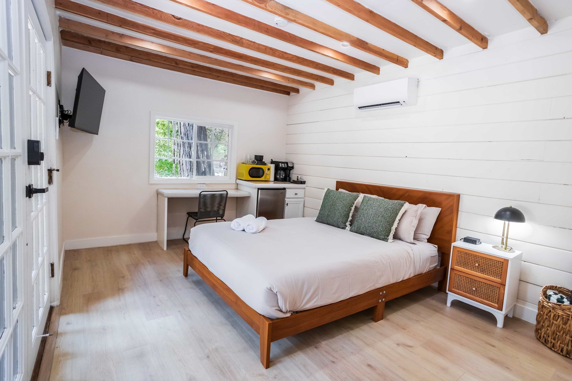 A bedroom with a king size bed , nightstand , desk and television.