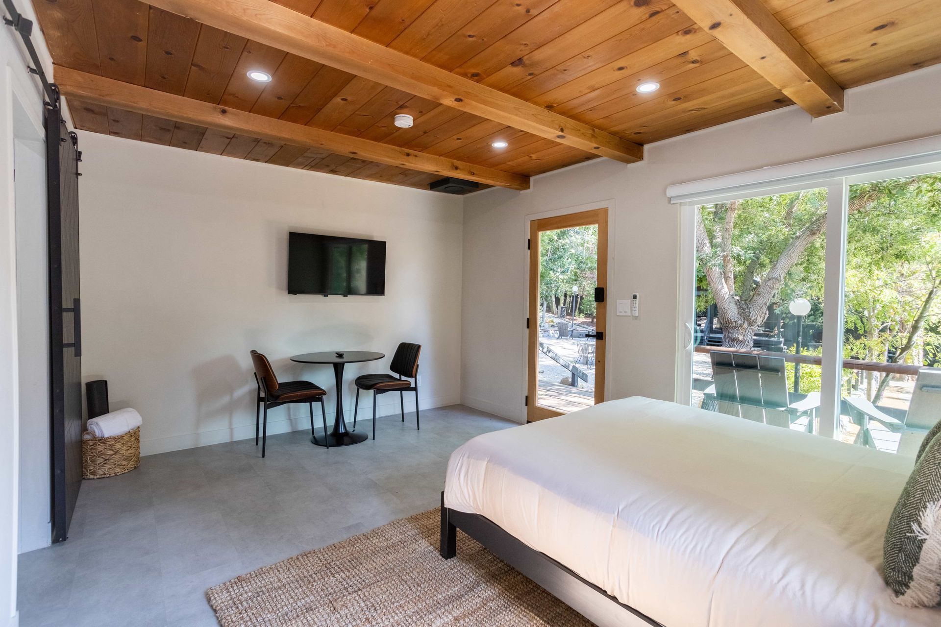 A bedroom with a king size bed , table and chairs.
