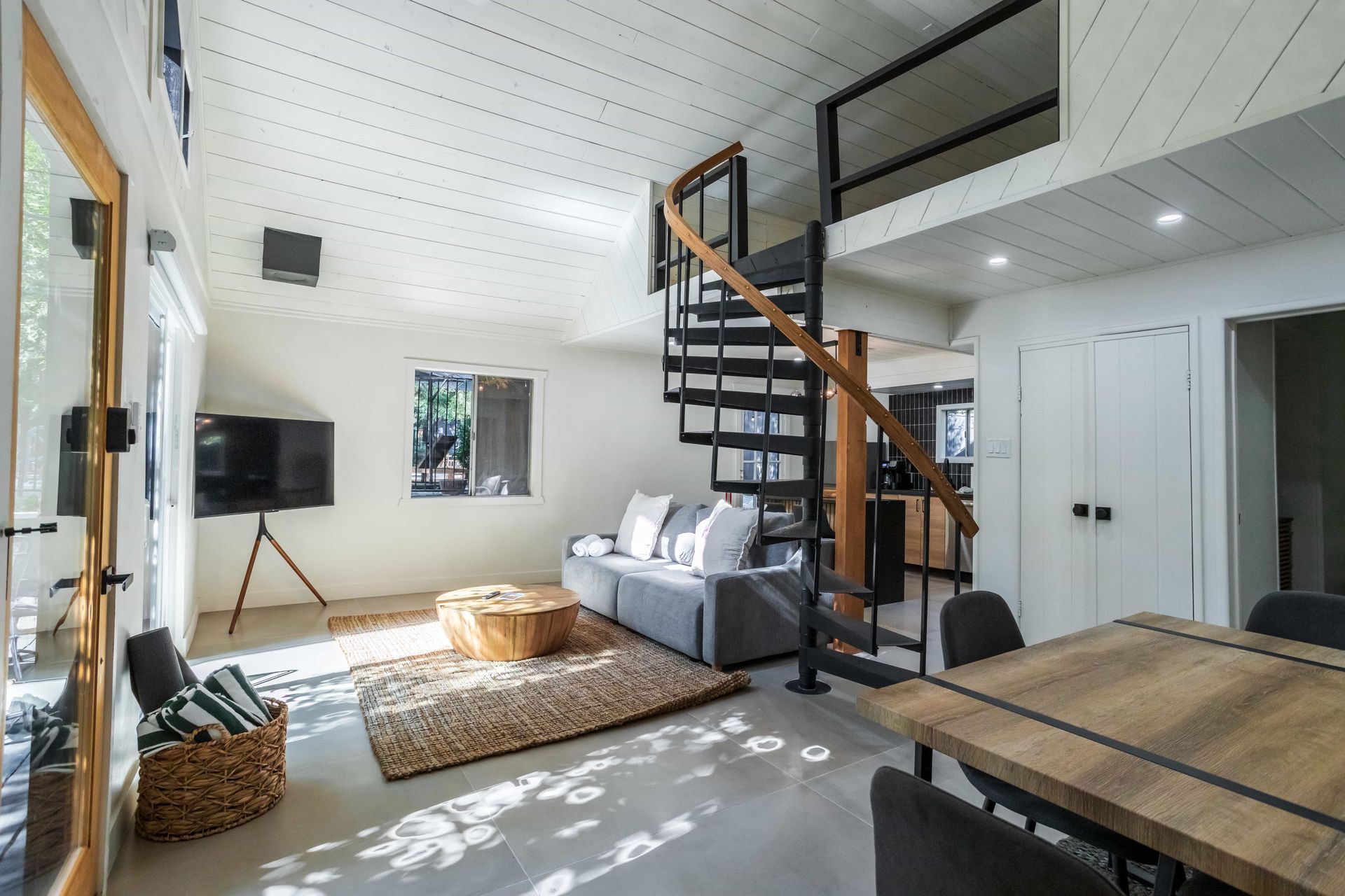 A living room with a spiral staircase leading to the second floor.