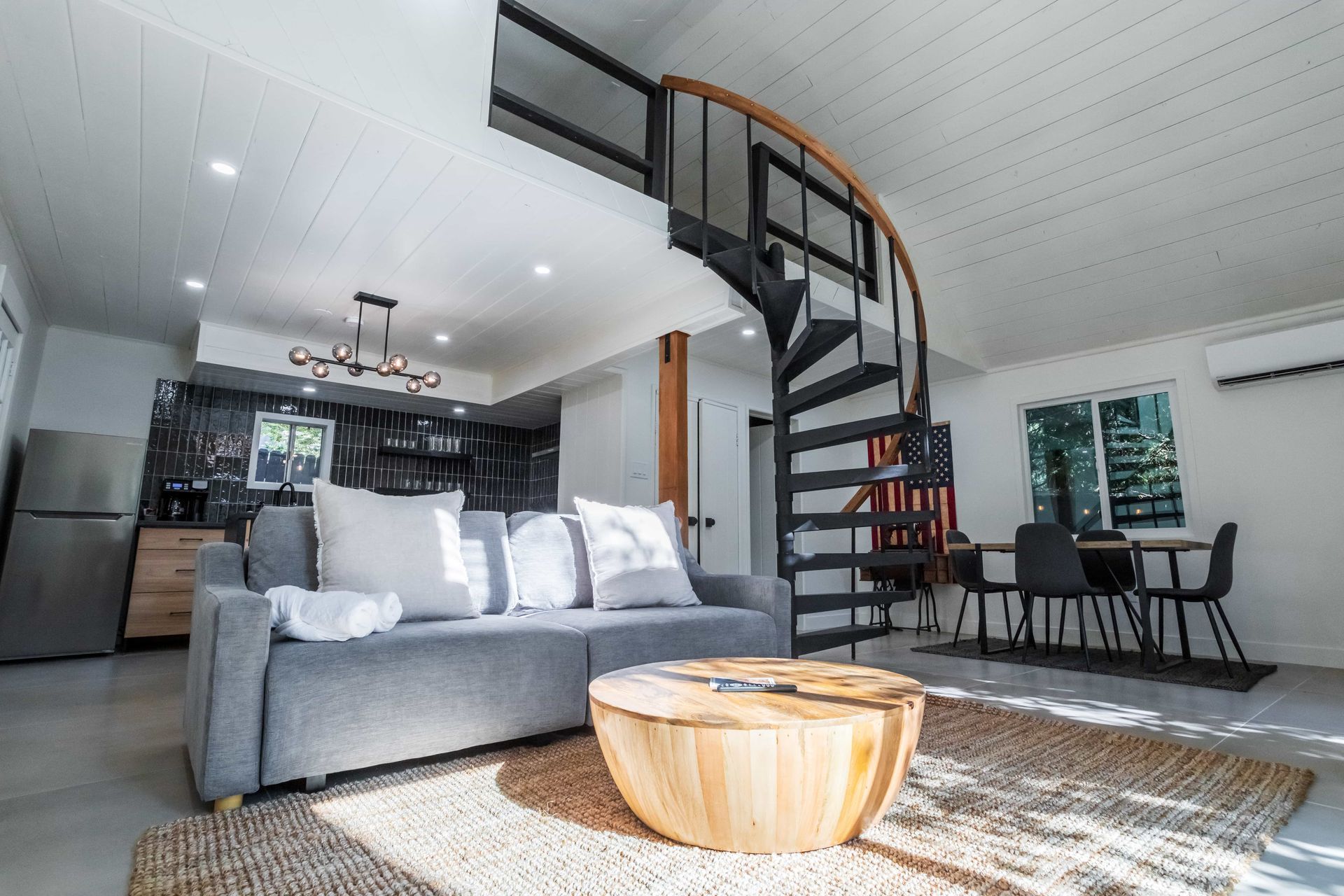 A living room with a spiral staircase and a couch.