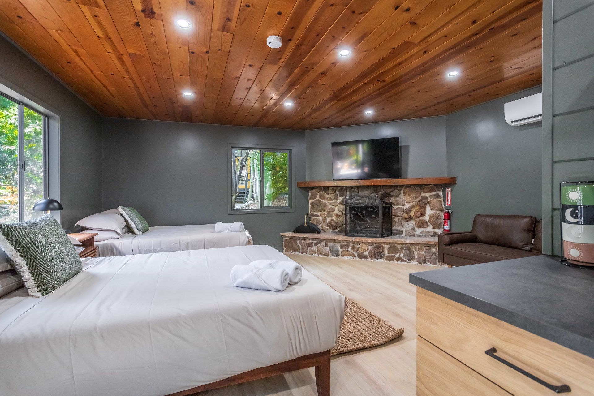 A bedroom with two beds , a fireplace and a television.