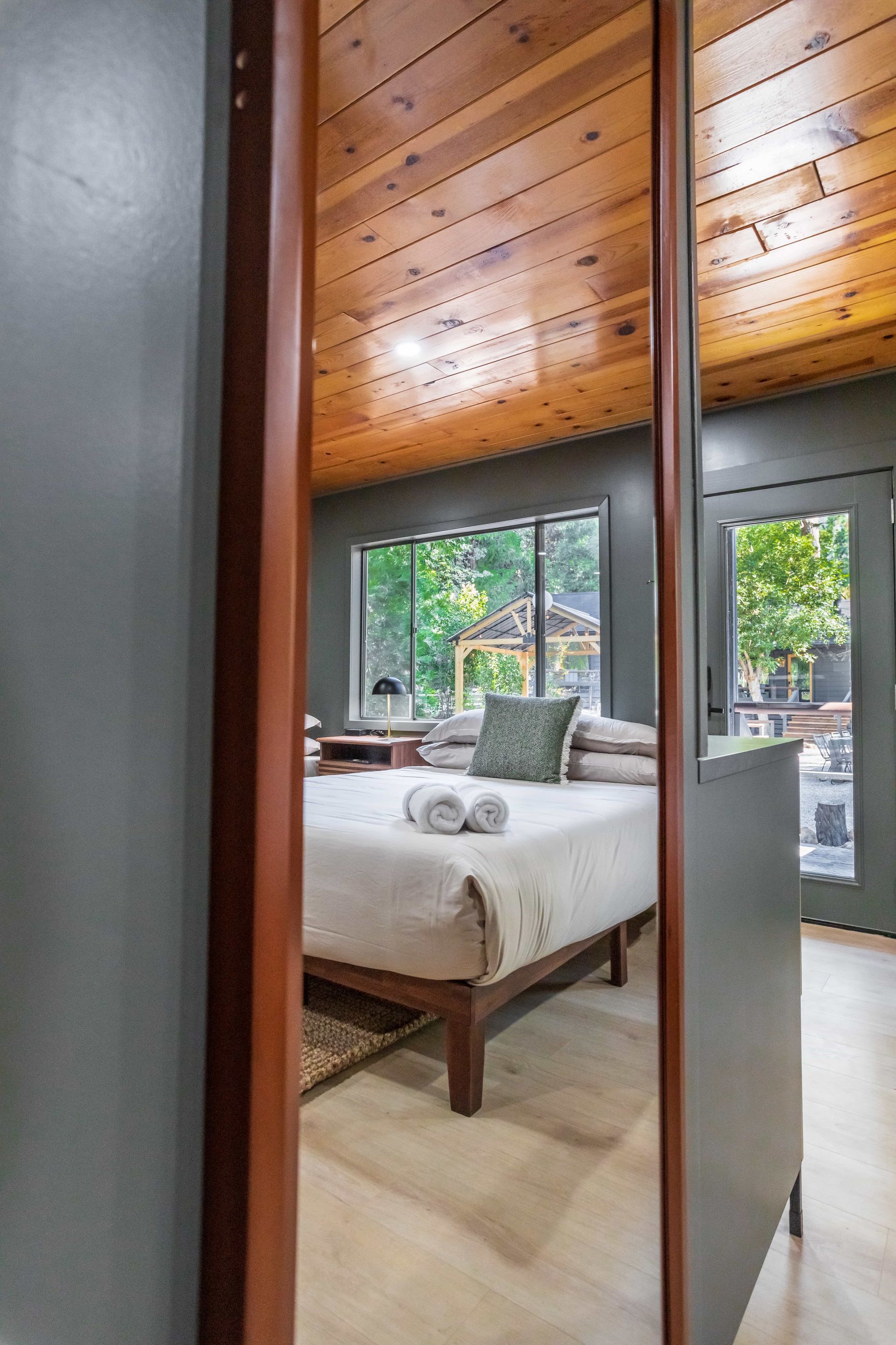 A bedroom with a bed and a large mirror.