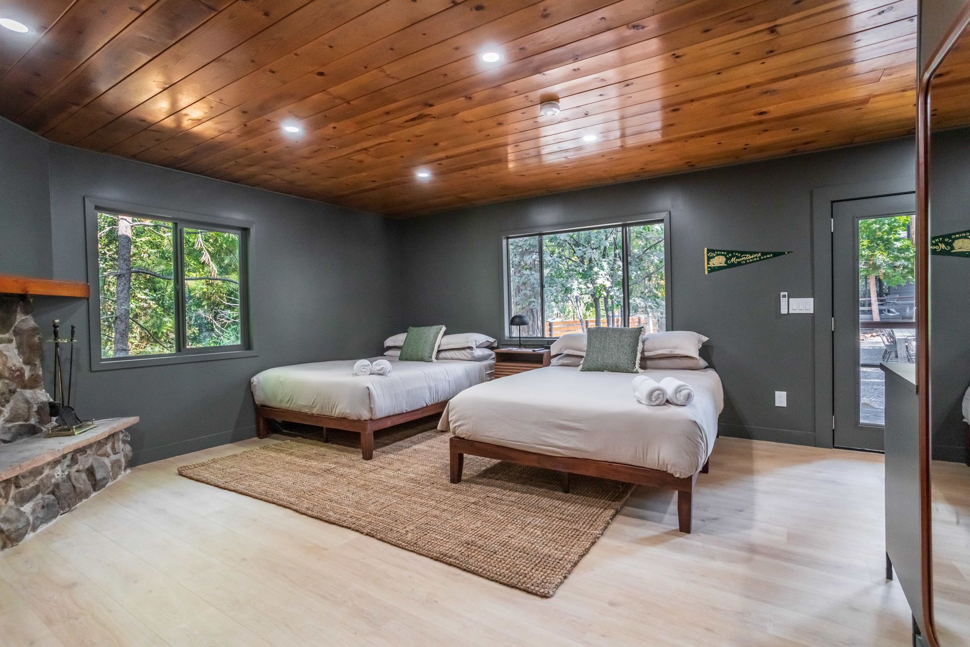 A large bedroom with two beds and a fireplace.