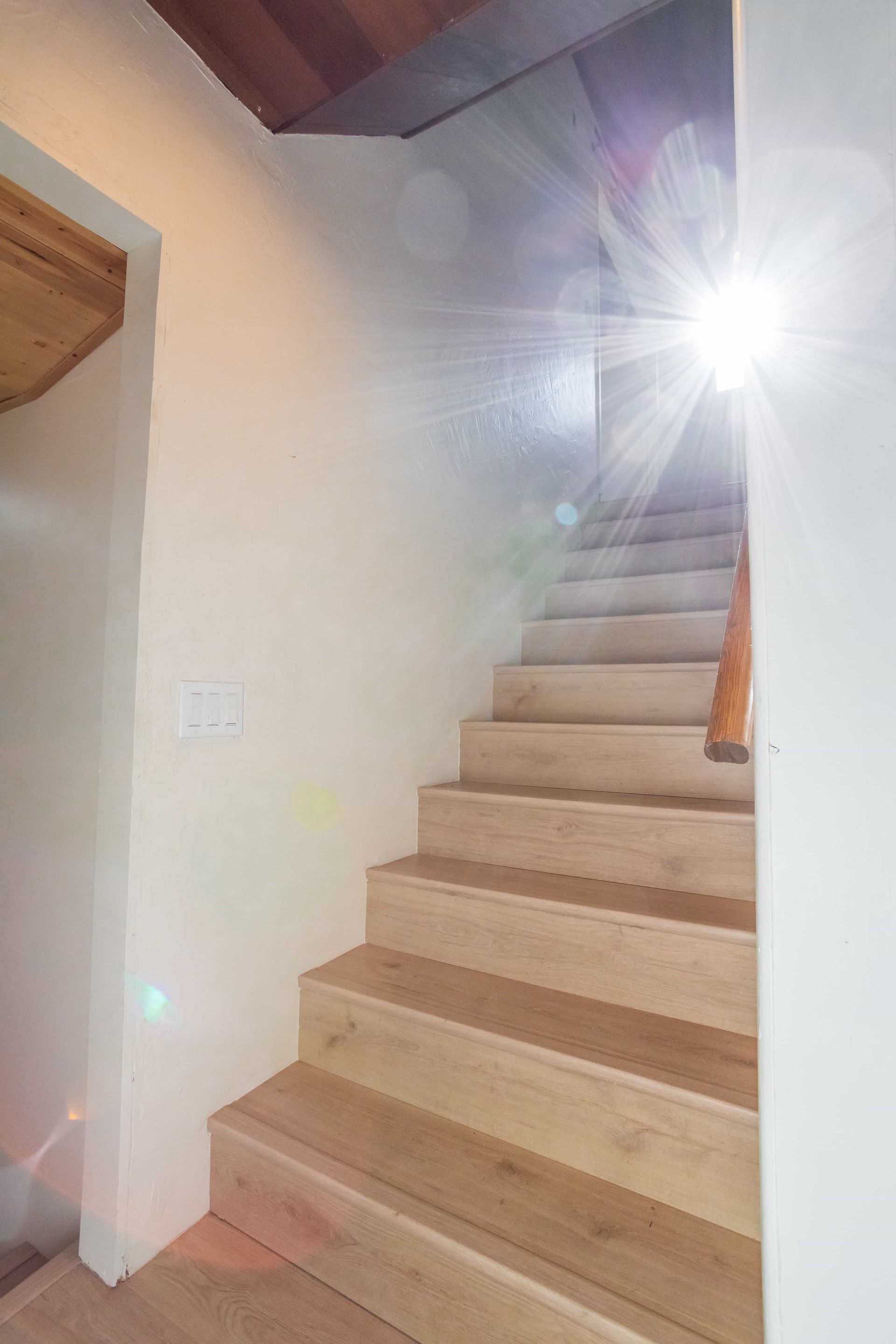A set of wooden stairs leading up to the second floor of a house.