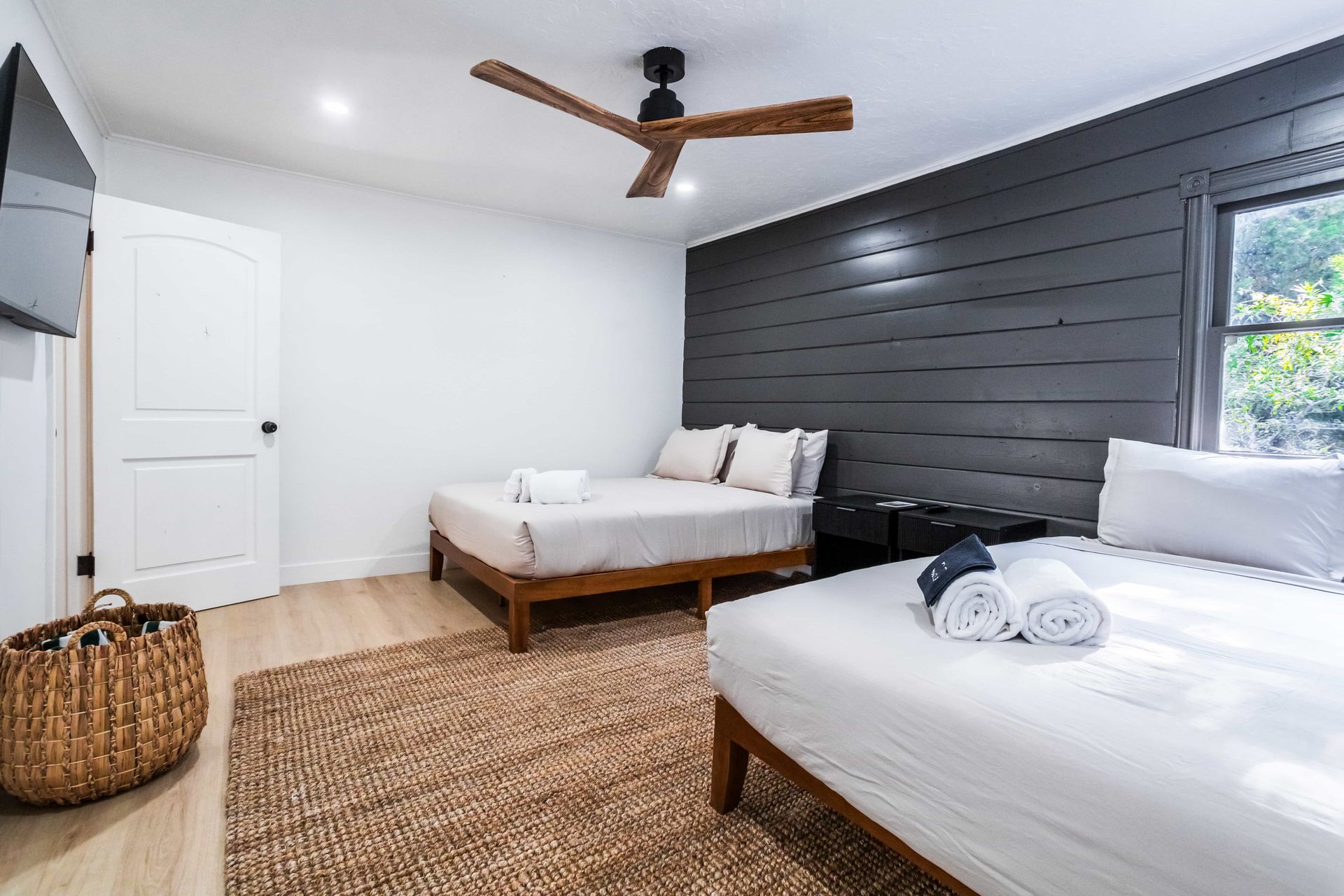 A bedroom with two beds and a ceiling fan.