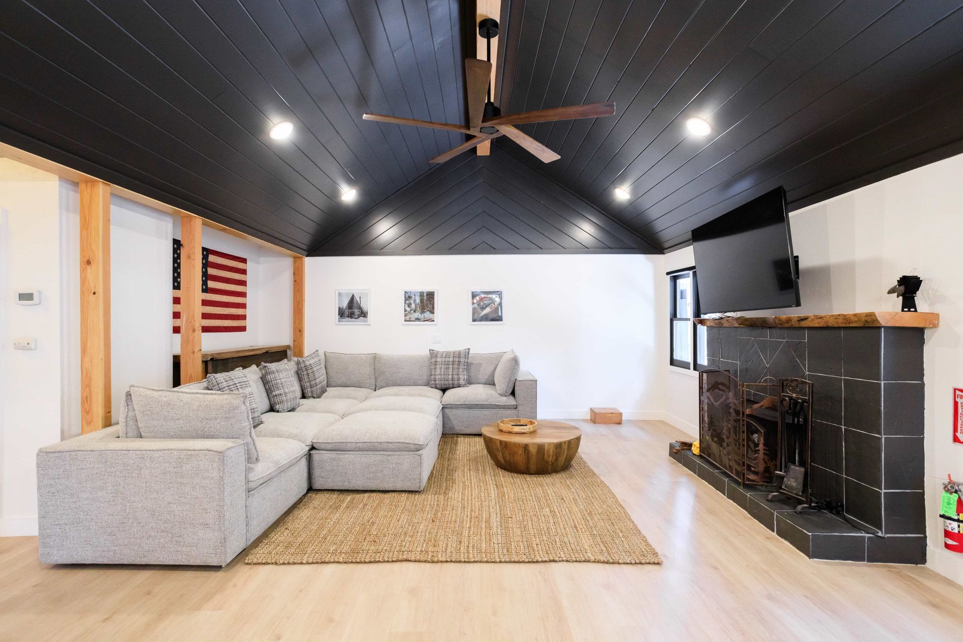 A living room with a large sectional couch and a fireplace