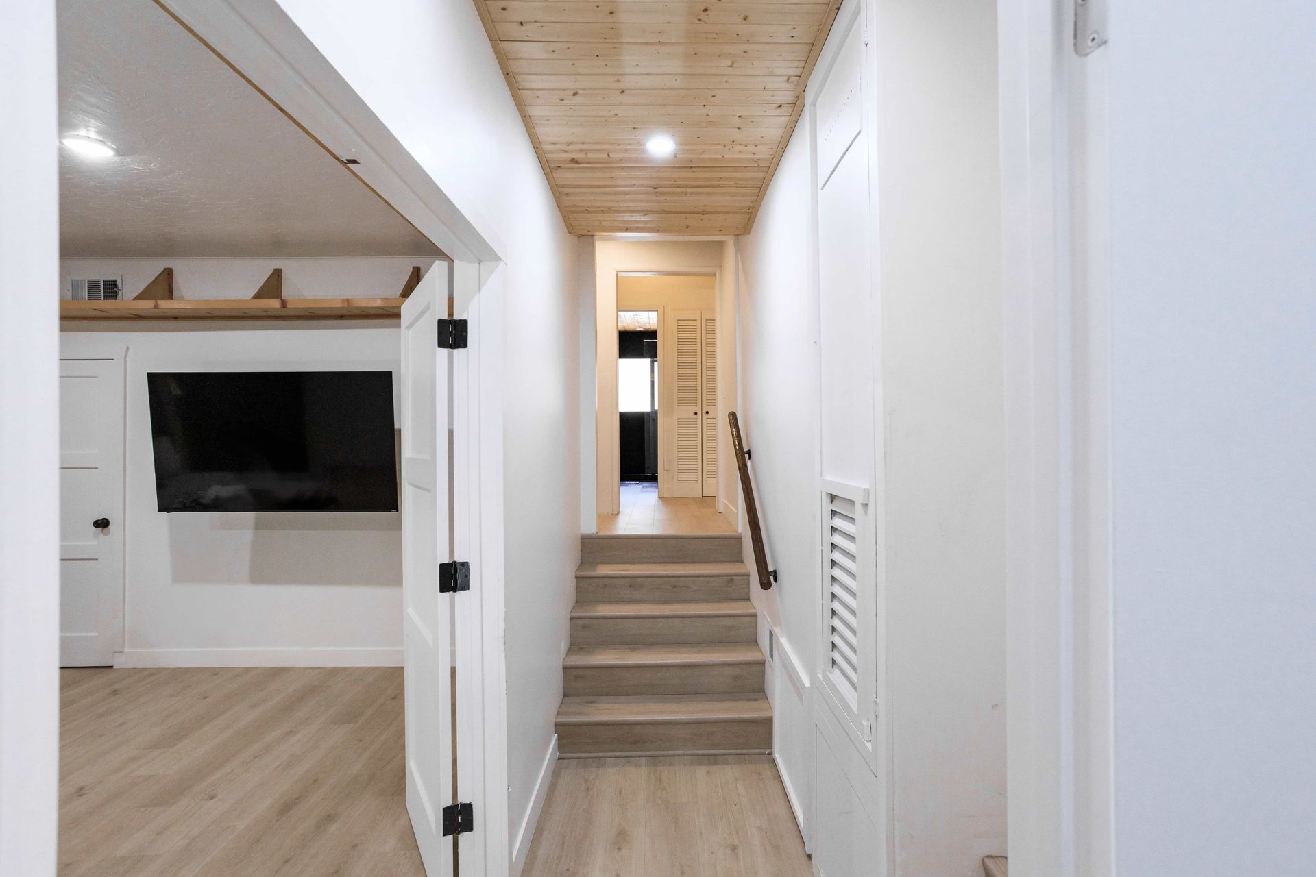 A hallway with stairs leading up to the second floor of a house.
