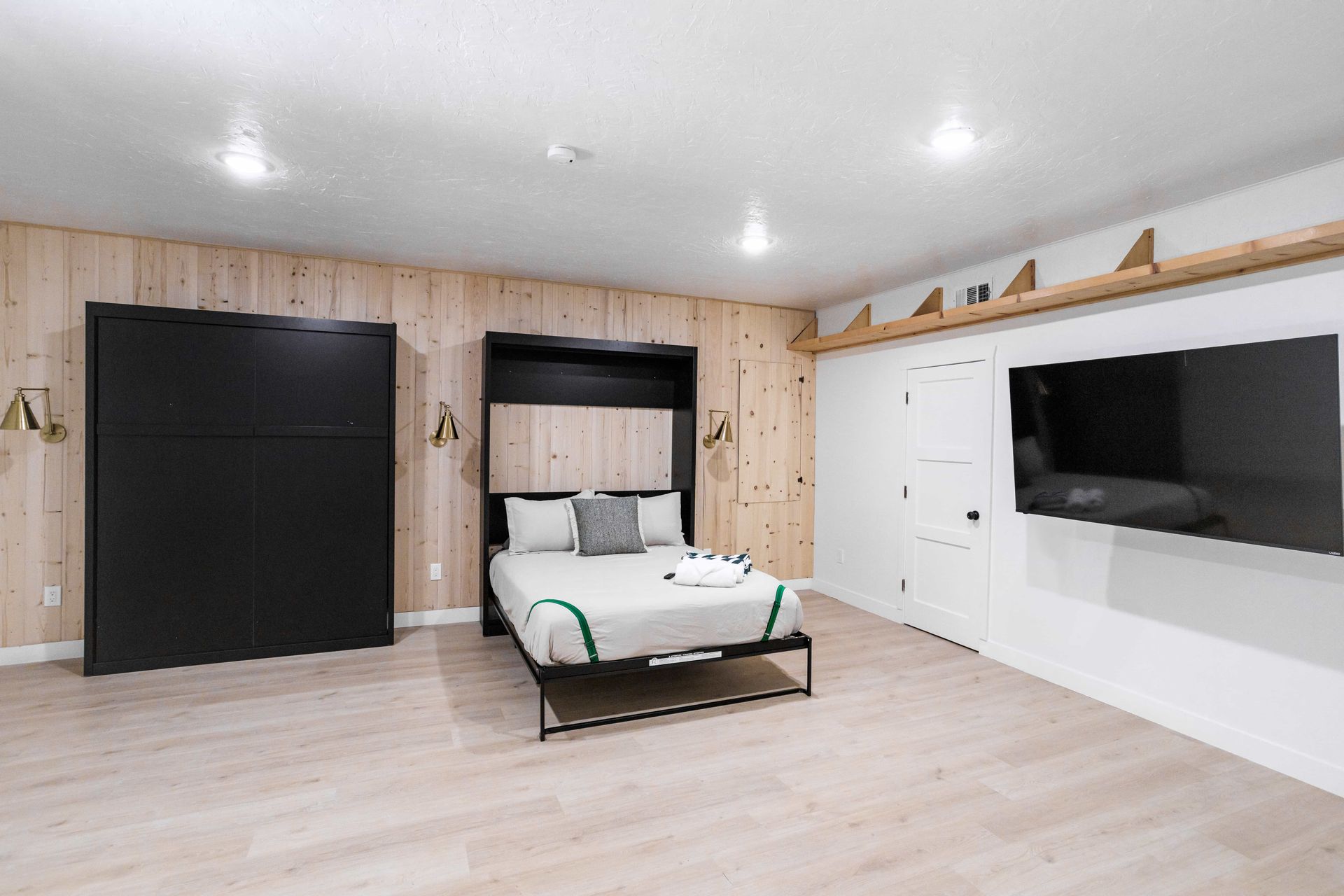 A bedroom with a bed and a flat screen tv.