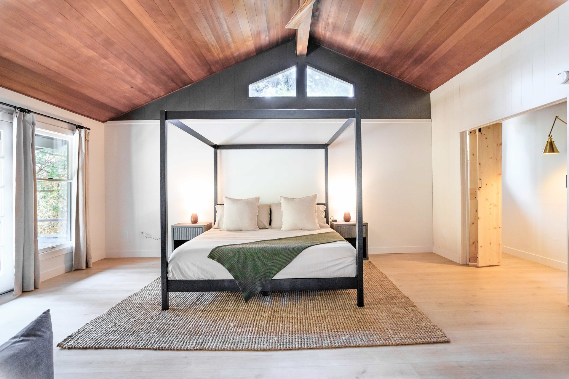 A bedroom with a canopy bed and a wooden ceiling.