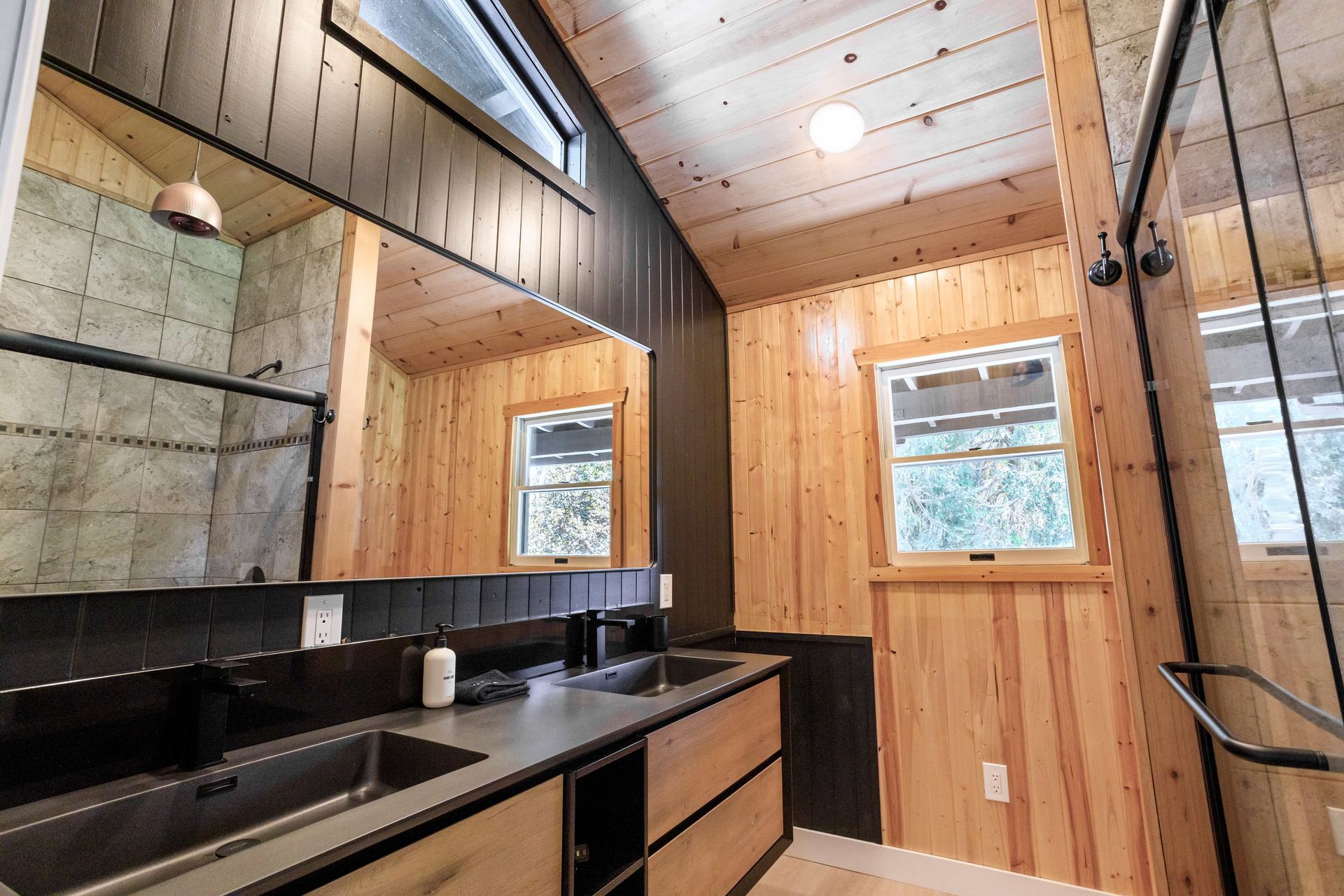 A bathroom with a sink , mirror , and shower.