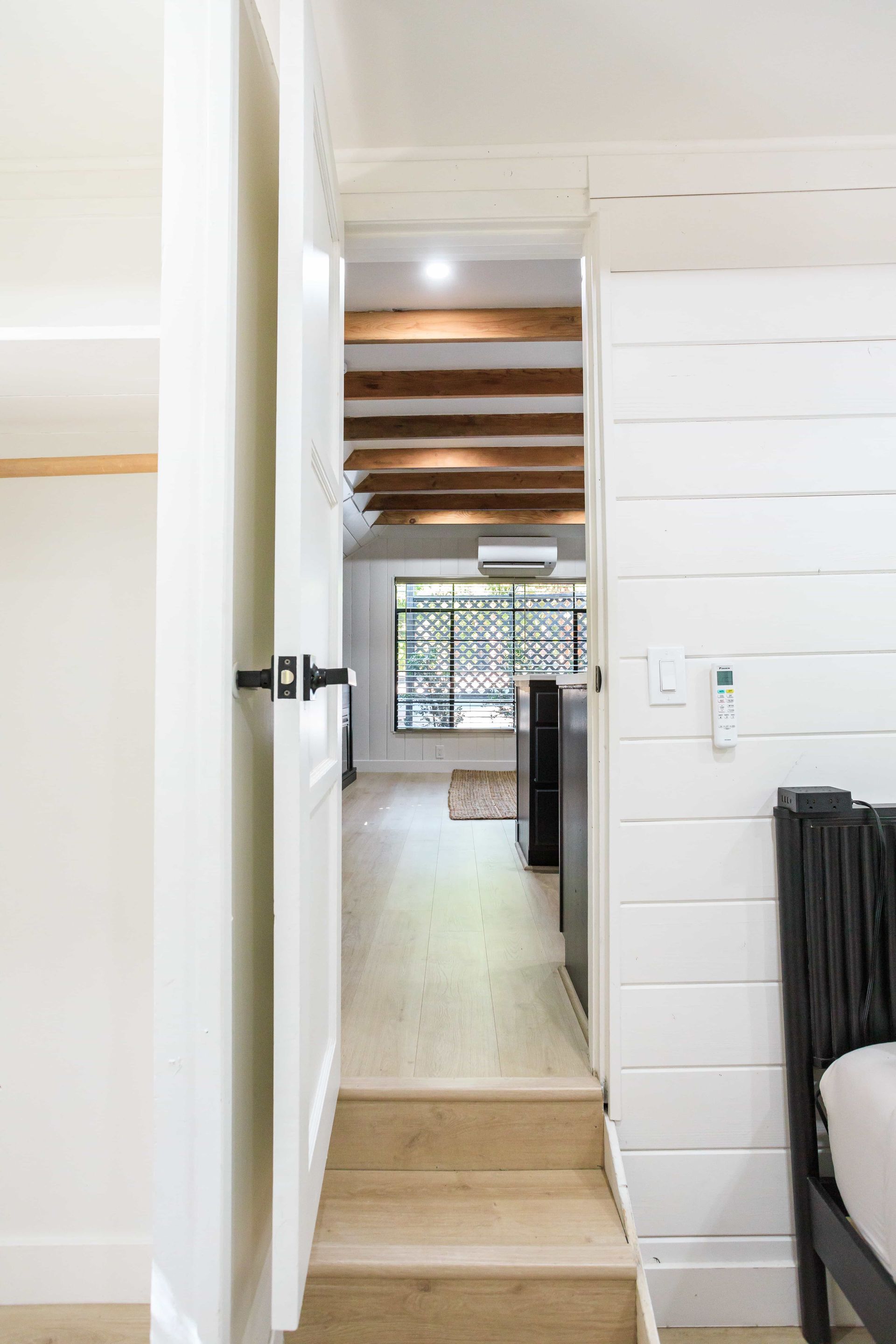 A hallway with stairs leading up to a bedroom in a house.