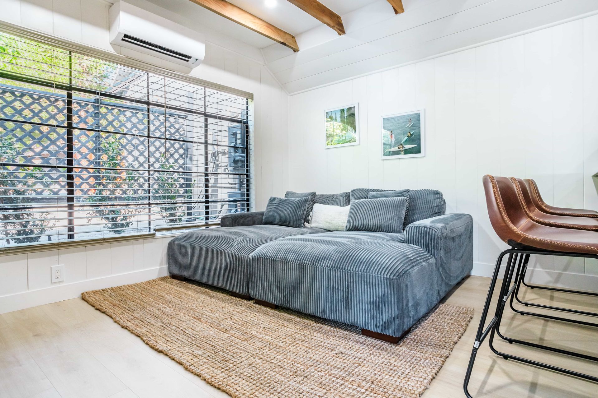 A living room with a couch , chairs and a rug.
