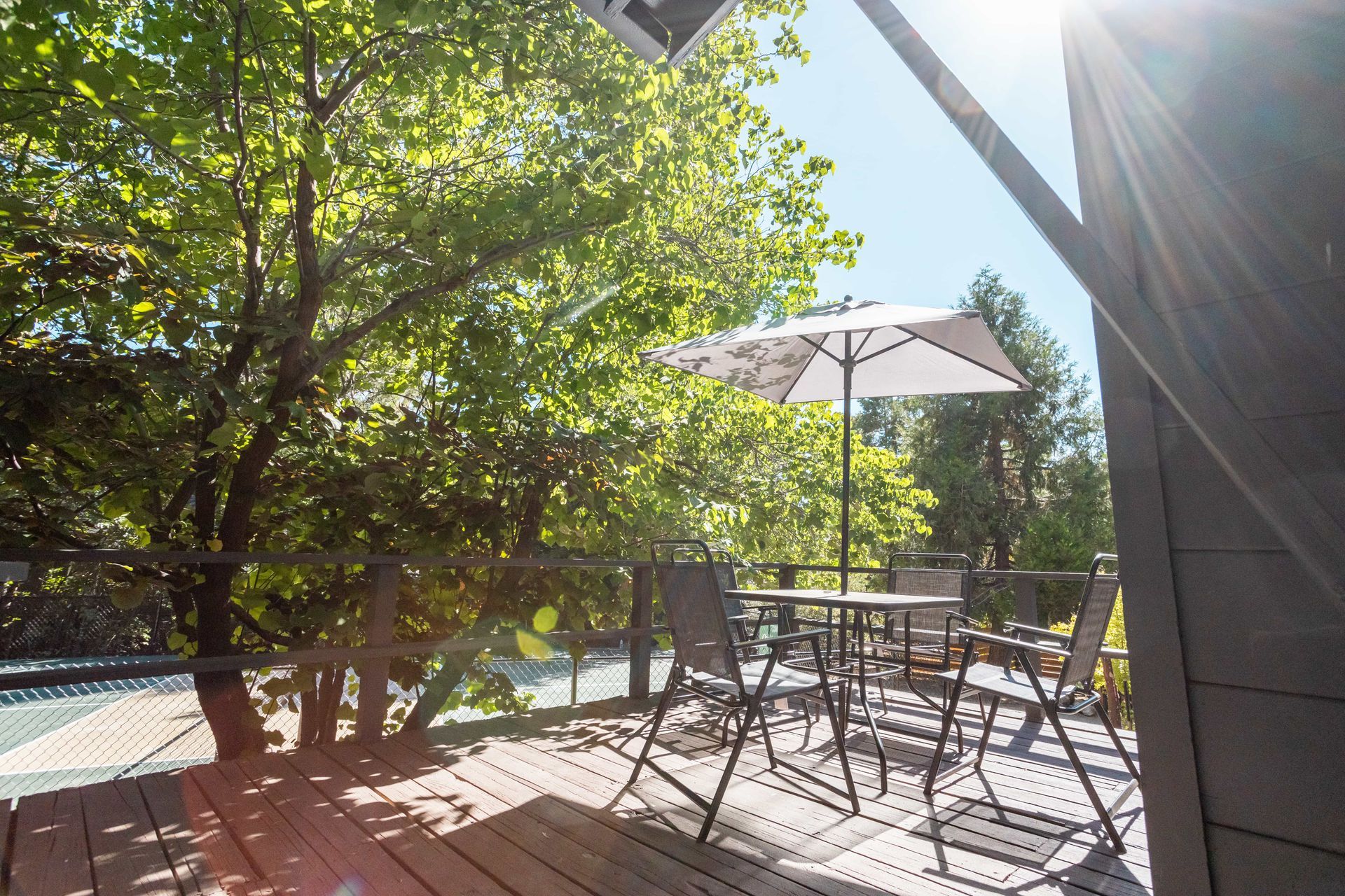 A wooden deck with a table and chairs and an umbrella