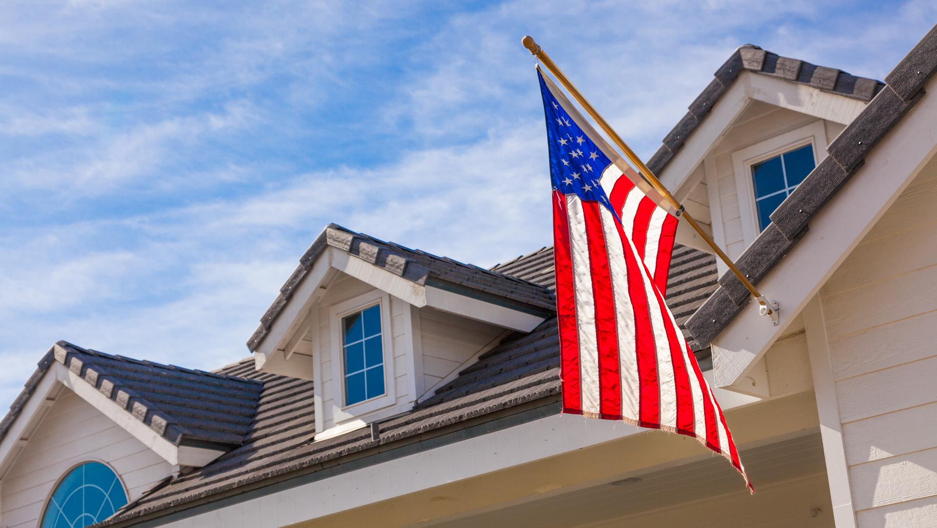 an american flag is flying from the roof of a house .