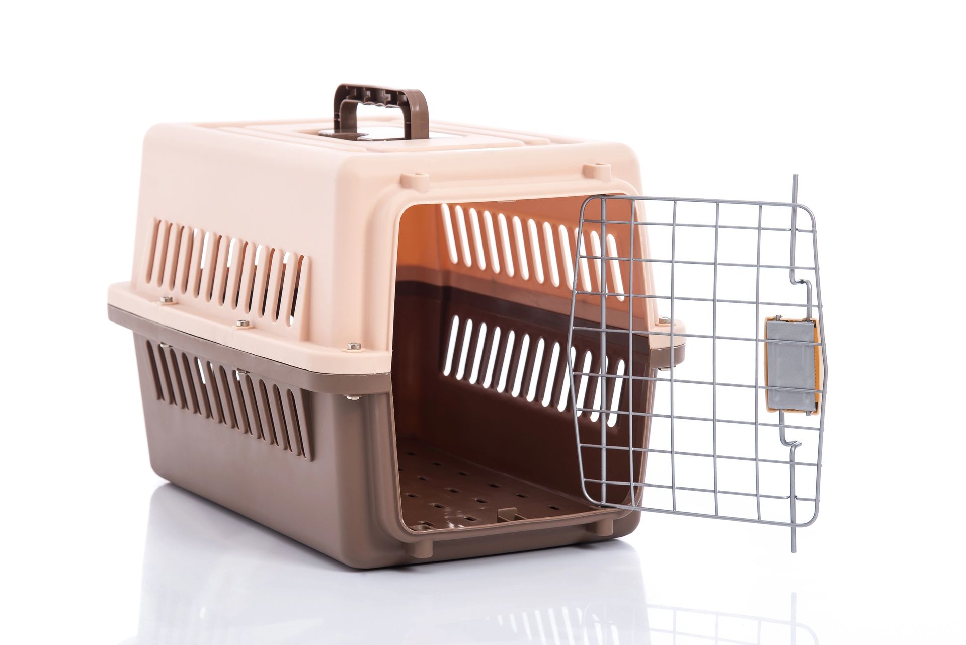 Trasportino per animali in plastica marrone chiaro e marrone con sportello metallico aperto e maniglia nella parte superiore.