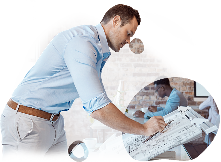 A man in a blue shirt is writing on a piece of paper.