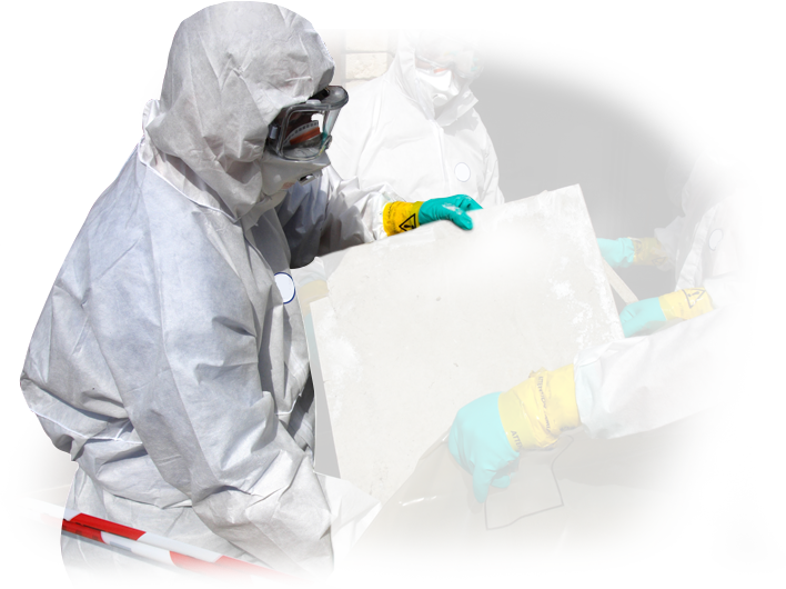A man in a protective suit is holding a piece of concrete