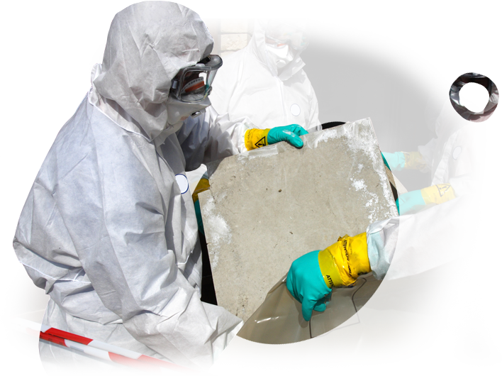 A man in a protective suit is holding a piece of concrete