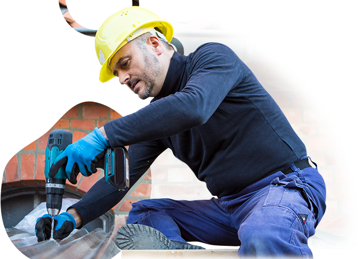 A man wearing a hard hat is working with a drill.