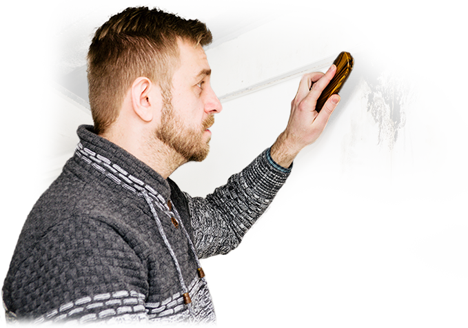 A man wearing a hard hat is working on a brick wall