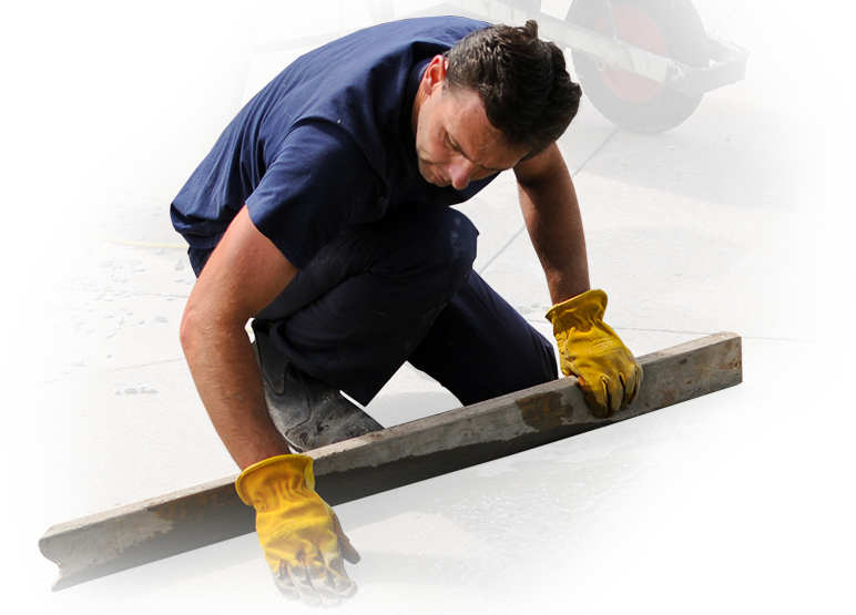 A man wearing yellow gloves is kneeling down using a level