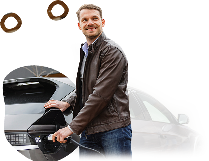 A man in a leather jacket is charging an electric car