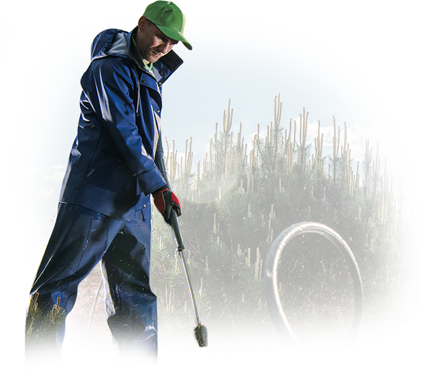 A man in a blue jacket and green hat is holding a shovel