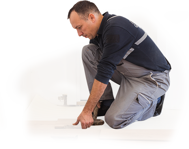 A man is kneeling down and measuring a piece of wood