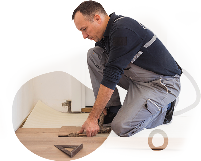 A man is kneeling down and measuring a piece of wood