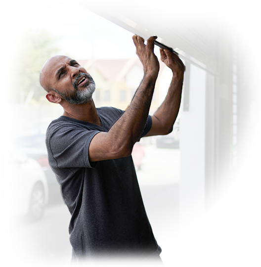 A man with a beard is working on a garage door