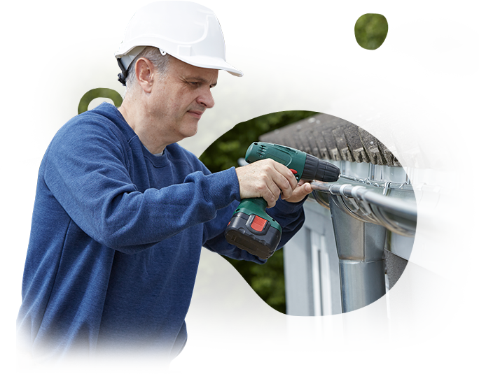 A man is fixing a gutter with a drill.