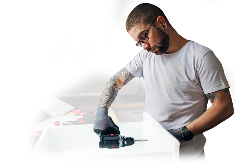 A man with a tattoo on his arm is holding a drill.