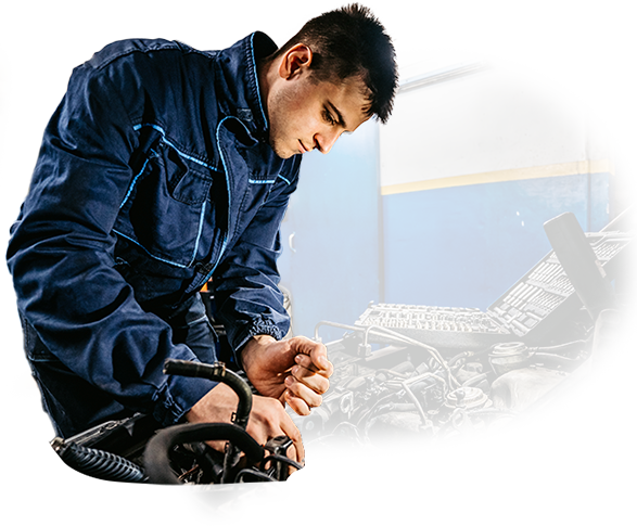 A man in a blue jacket is working on a car engine.