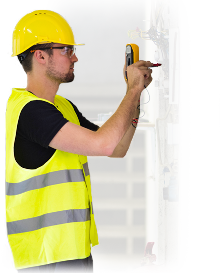 A man wearing a hard hat and safety vest is using a multimeter