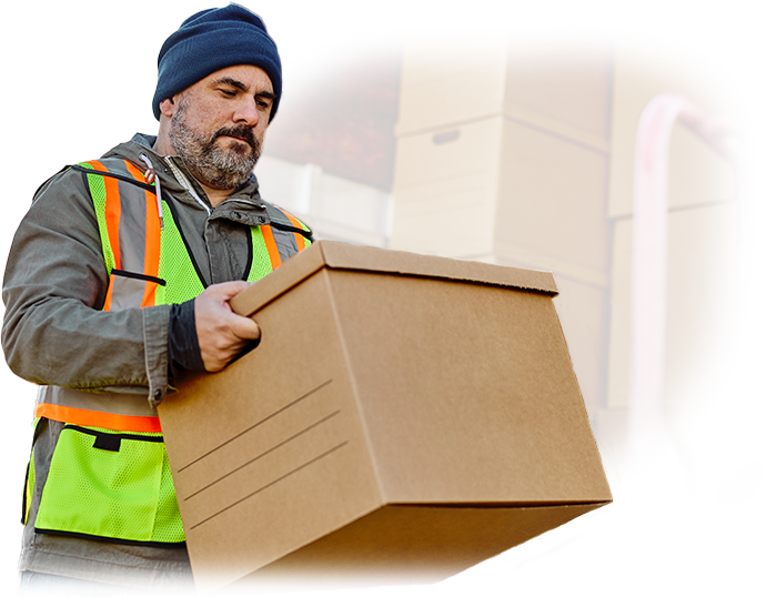 A man in a safety vest is carrying a cardboard box.